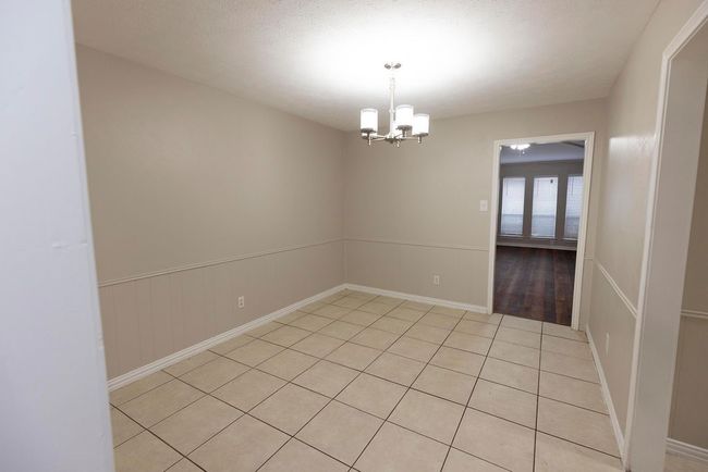 Spare room featuring a chandelier, light tile patterned flooring, and baseboards | Image 10
