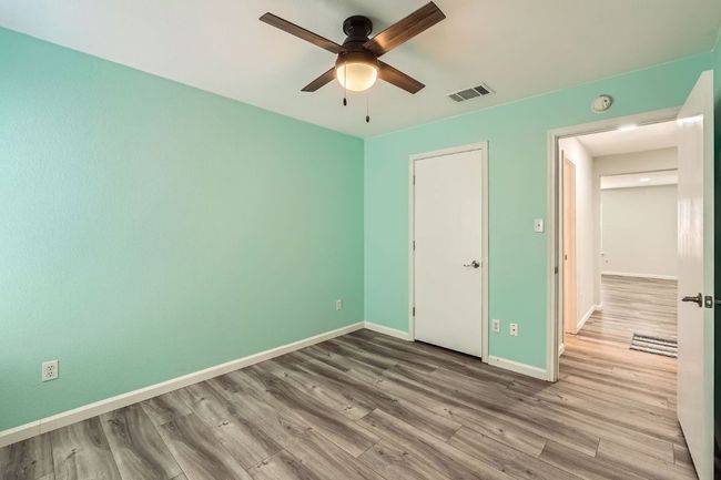 Unfurnished bedroom with baseboards, visible vents, a ceiling fan, and wood finished floors | Image 22