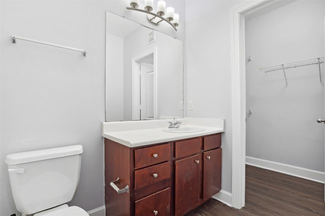 Bathroom with visible vents, baseboards, toilet, wood finished floors, and vanity | Image 14