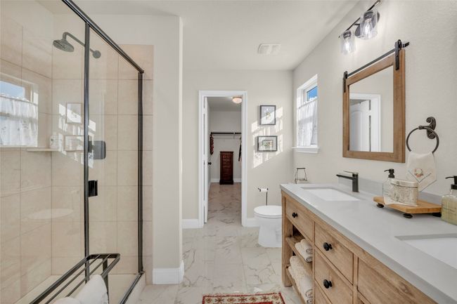 Full bathroom with a double vanity sink, toilet, marble finish floor, and a walk-in shower | Image 20
