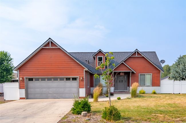 View of front of home with concrete driveway, roof with shingles, an attached garage, a front lawn, and fence | Image 14