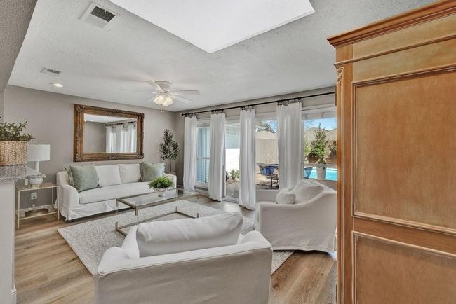 Living room with visible vents, light wood-style flooring, and a ceiling fan | Image 9