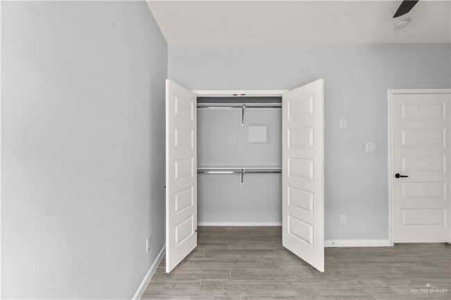 Unfurnished bedroom featuring a closet, baseboards, and wood finished floors | Image 5