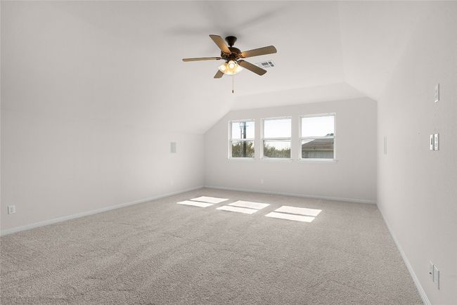 Bonus room with a ceiling fan, carpet, baseboards, visible vents, and vaulted ceiling | Image 37