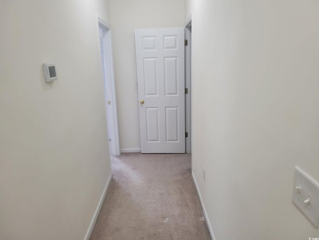 Hallway with light carpet and baseboards | Image 26