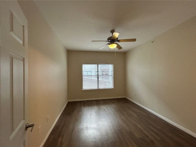 Unfurnished room with ceiling fan, dark wood finished floors, and baseboards | Image 17