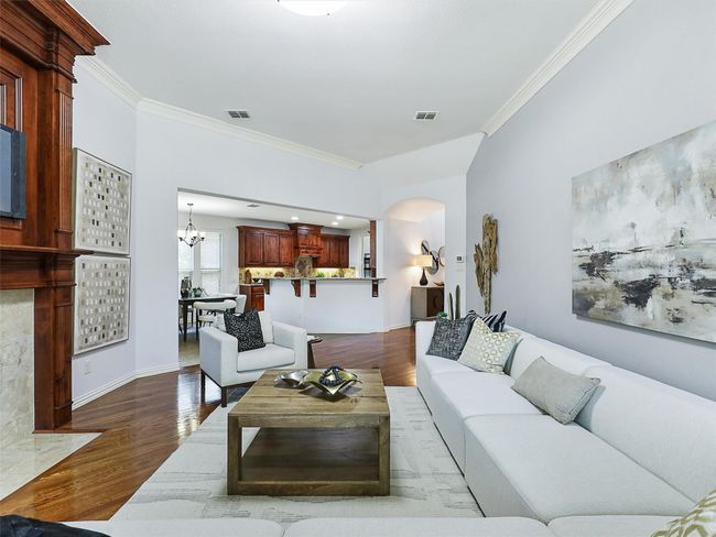 Living room with ornamental molding, dark wood finished floors, arched walkways, and a chandelier | Image 18