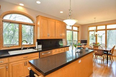 Gorgeous eat in kitchen with black quartz countertops, stainless appliances and views to the serene park reserve | Image 2