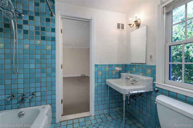 Full bathroom featuring tile patterned flooring, bathtub / shower combination, tile walls, and a wainscoted wall | Image 24