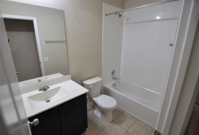 Full bath with toilet, tile patterned floors, shower / bathtub combination, and vanity | Image 5