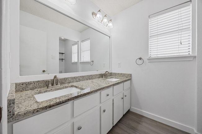 Bathroom with baseboards, wood finished floors, a sink, and double vanity | Image 18