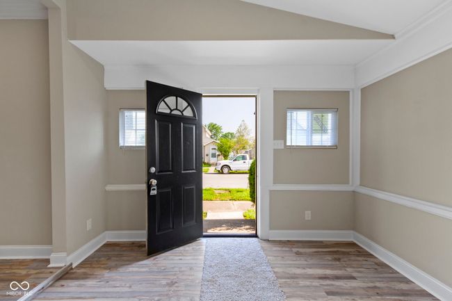 entryway featuring wood finished floors, vaulted ceiling, and baseboards | Image 5