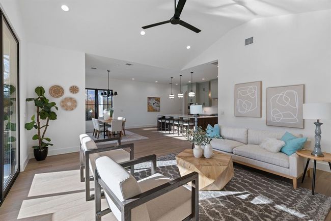 Living room featuring a ceiling fan, wood finished floors, baseboards, high vaulted ceiling, and recessed lighting | Image 23