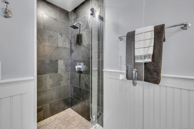 Walk-in shower with built-in bench, tile surround. | Image 19