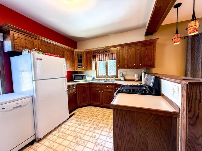 Natural wood cabinets line the kitchen | Image 7