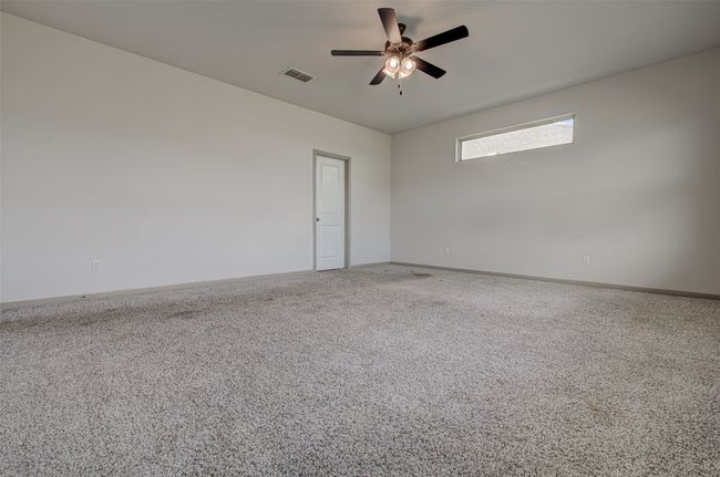 Carpeted spare room featuring ceiling fan and baseboards | Image 17