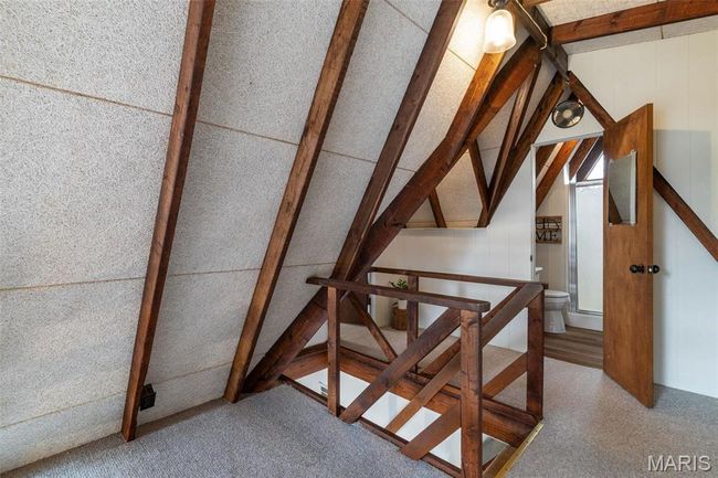Staircase with carpet flooring and vaulted ceiling with beams | Image 35