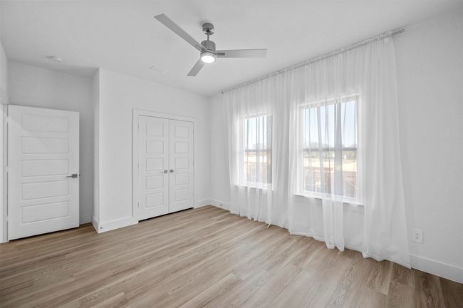 Unfurnished bedroom featuring wood finished floors, a closet, and a ceiling fan | Image 16
