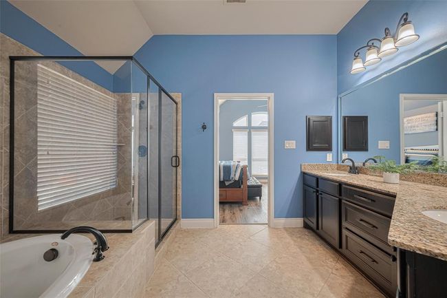 The primary bathroom boasts a soaking tub, separate shower, and dual vanities, providing plenty of space for two to get ready comfortably each day. | Image 26