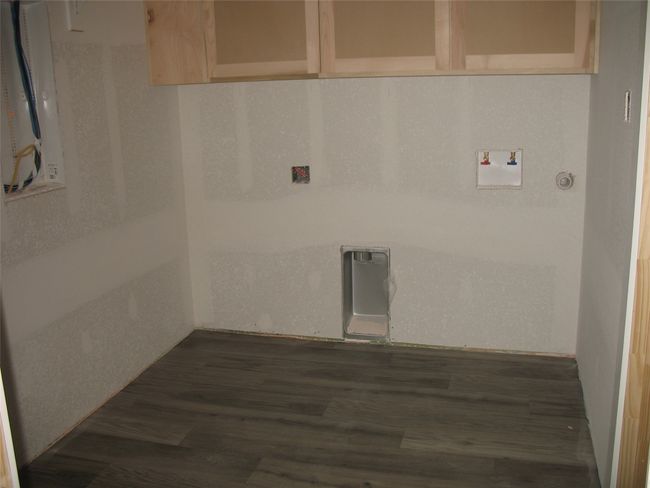Laundry area featuring dark wood finished floors and washer hookup | Image 14