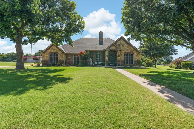 View of front of property with stone siding, a front yard, and a chimney | Image 4