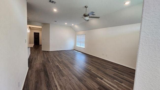 Spare room featuring ceiling fan, vaulted ceiling, baseboards, dark wood-type flooring, and recessed lighting | Image 10