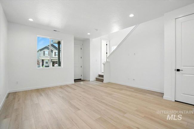 Unfurnished living room with light wood-type flooring, stairs, and recessed lighting | Image 6
