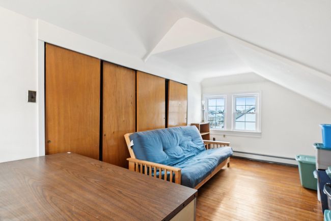 Office space featuring a baseboard heating unit, vaulted ceiling, and light wood-type flooring | Image 23