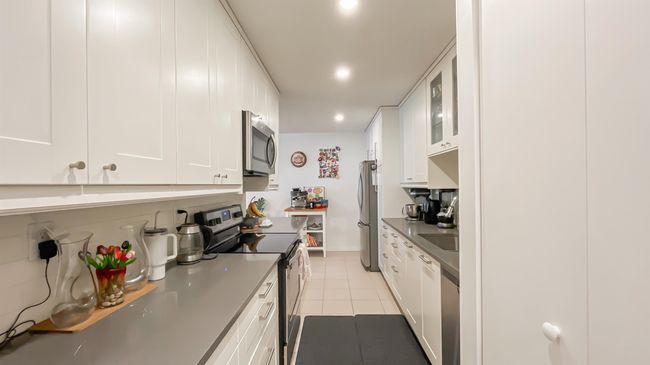 Kitchen with recessed lighting, light tile patterned floors, white cabinetry, and appliances with stainless steel finishes | Image 7