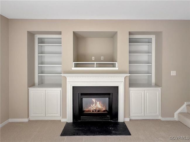 Detailed view of carpet flooring, a fireplace with flush hearth, and built in features | Image 9