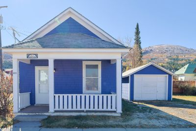 Bungalow-style home featuring covered porch, a mountain view, a garage, and an outdoor structure | Image 1