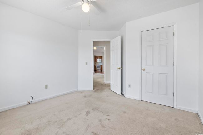 Unfurnished bedroom with carpet flooring, baseboards, and a ceiling fan | Image 26