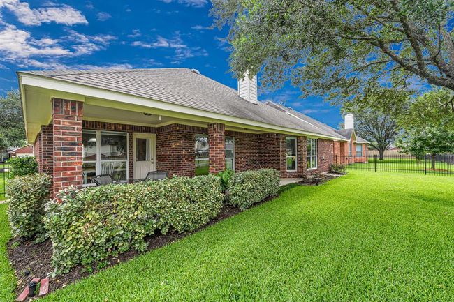 Expansive backyard with covered patio and lush landscaping offers a serene retreat for outdoor living. | Image 21
