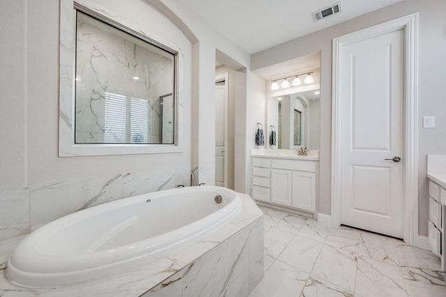 Full bath featuring vanity, a garden tub, and marble finish flooring | Image 15