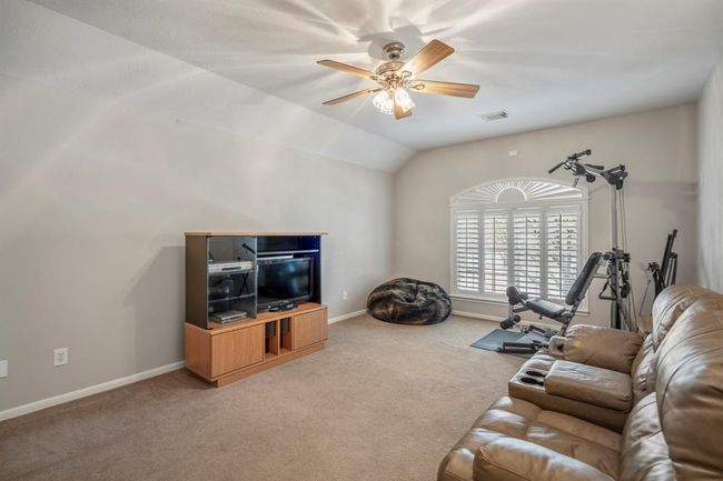 The upstairs game room offers a versatile space, with plantation shutters adorning the window, allowing natural light to fill the room while maintaining privacy. | Image 26