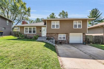 Split level home featuring a front lawn and a garage | Image 1