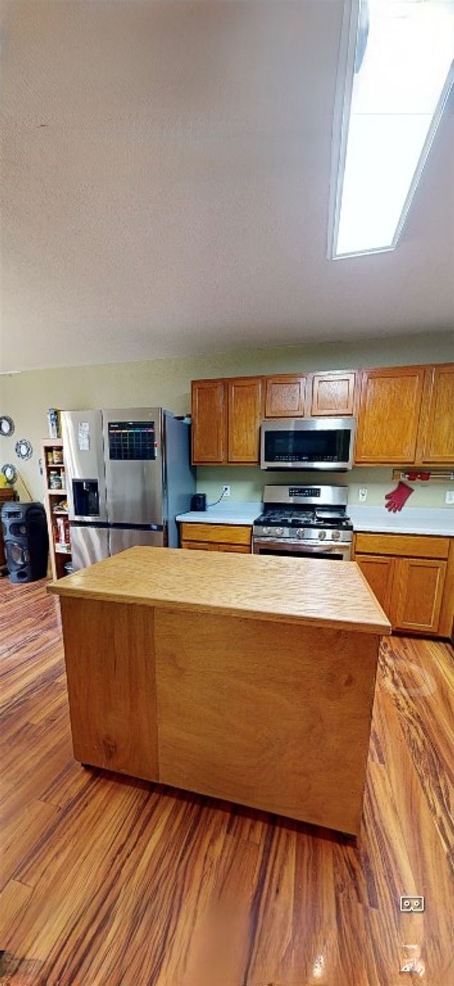 Kitchen featuring stainless steel appliances, wood counters, light wood finished floors, and brown cabinets | Image 15