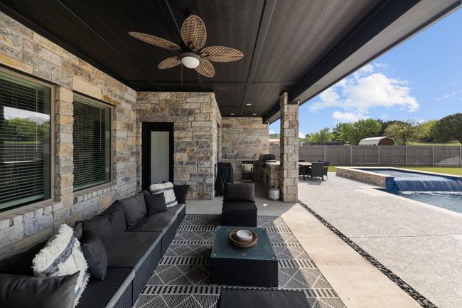 View of patio / terrace with a fenced in pool, a fenced backyard, ceiling fan, and an outdoor hangout area | Image 33