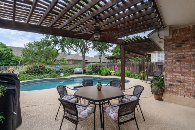 View of pool featuring a pergola, fenced backyard, outdoor dining area, and a pool / hot tub. | Image 31