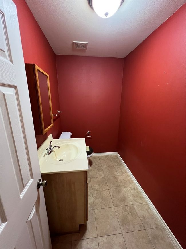 Bathroom with tile patterned flooring, vanity, baseboards, and a textured ceiling | Image 13