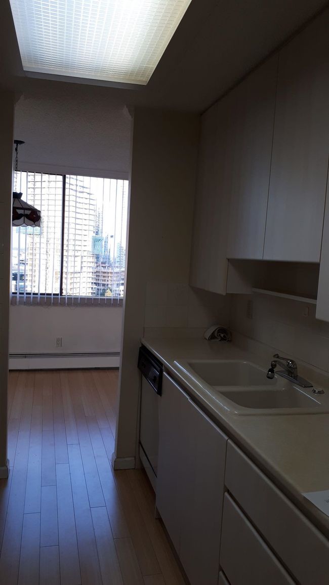 Kitchen featuring a sink, baseboard heating, dishwasher, and light countertops | Image 17