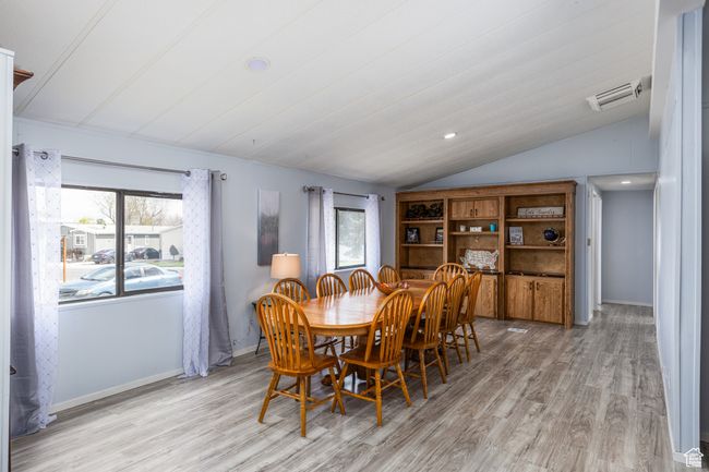 Dining area with a wealth of natural light, light wood finished floors, and vaulted ceiling | Image 9