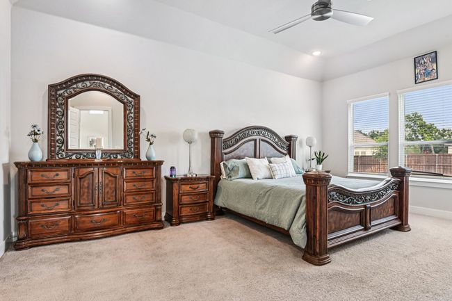 Bedroom featuring light carpet, a ceiling fan, and lofted ceiling | Image 17