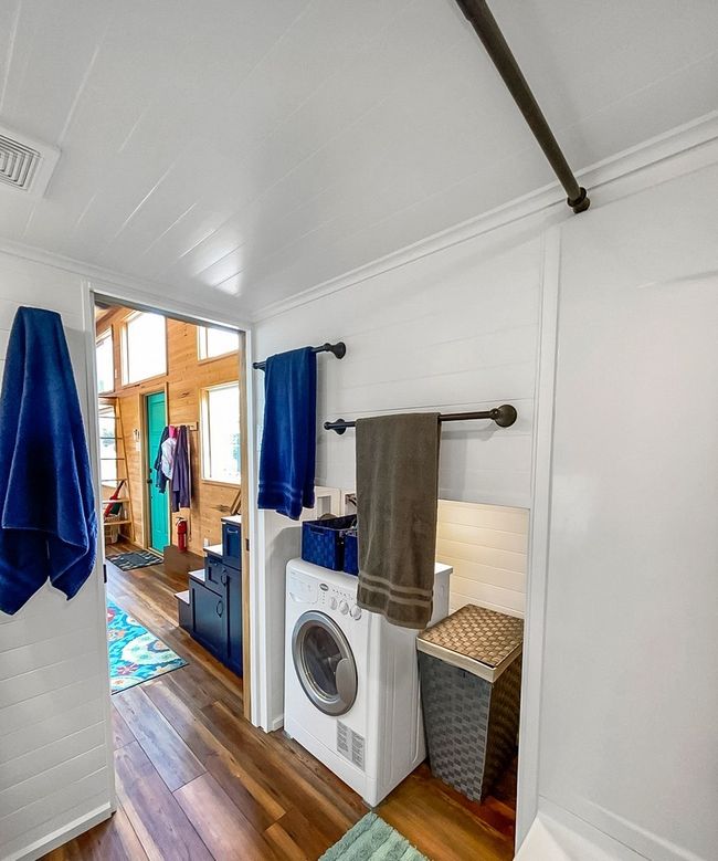Washroom featuring dark wood-style floors, washer / clothes dryer, and wood walls | Image 30