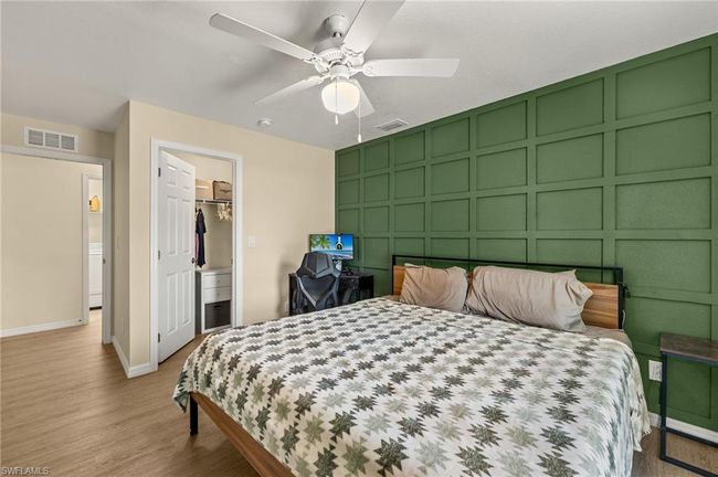 Bedroom with an accent wall, a decorative wall, light wood-style flooring, and visible vents | Image 11