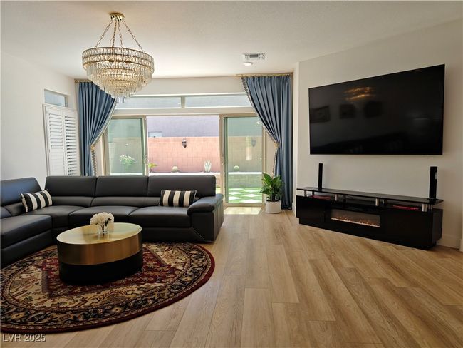 Living area featuring visible vents, wood finished floors, and a chandelier | Image 10