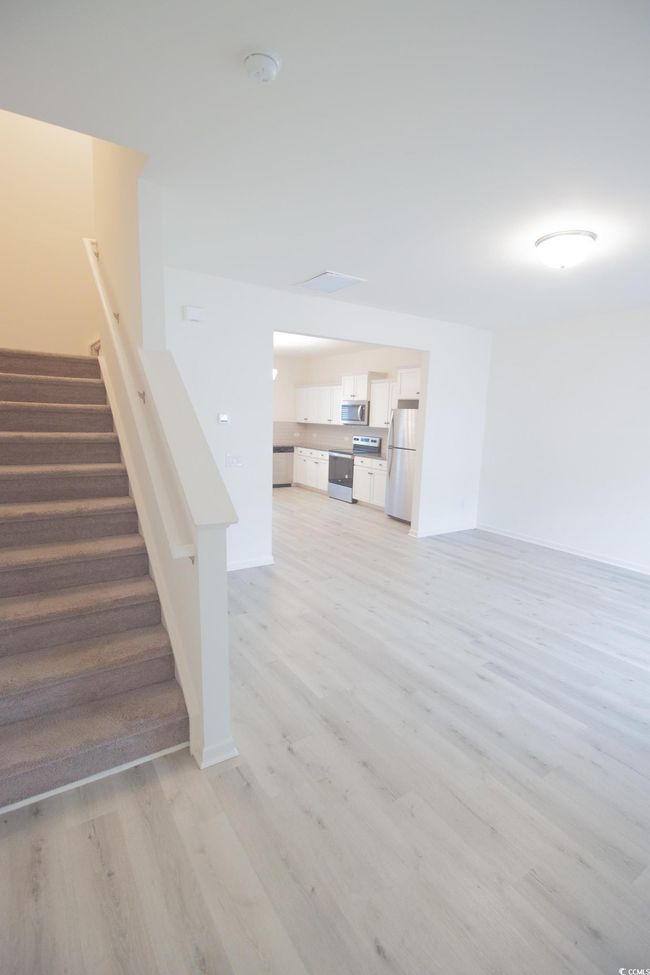 Unfurnished living room with light wood-style flooring and stairway | Image 8