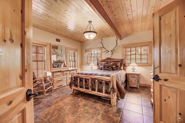 Bedroom with a wood ceiling with exposed beams | Image 48
