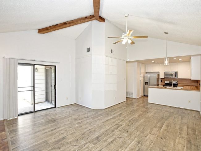 Unfurnished living room featuring a ceiling fan, visible vents, and light wood-type flooring | Image 4