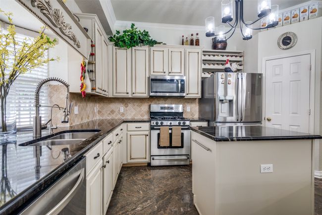 Kitchen with stainless steel appliances and window behind the sink for added natural light. | Image 15